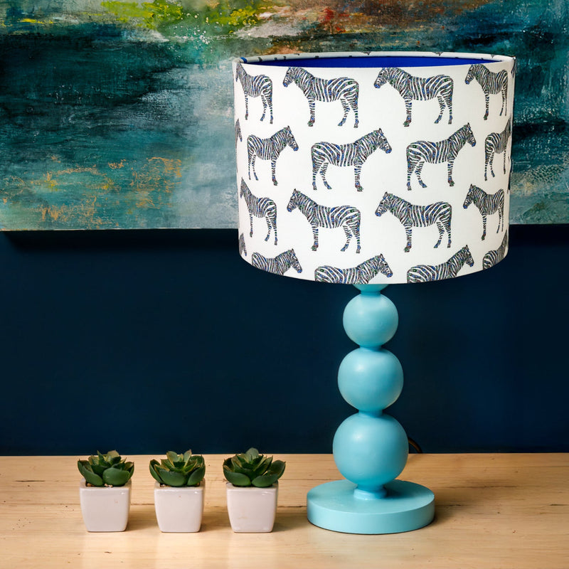 Table lamp with zebra pattern drum shade.
